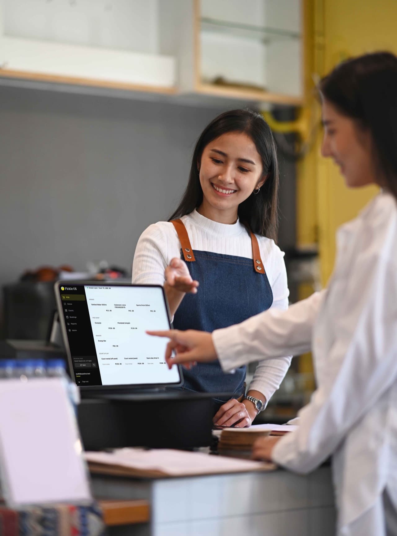 Staff taking a customer's order and payment at the counter
